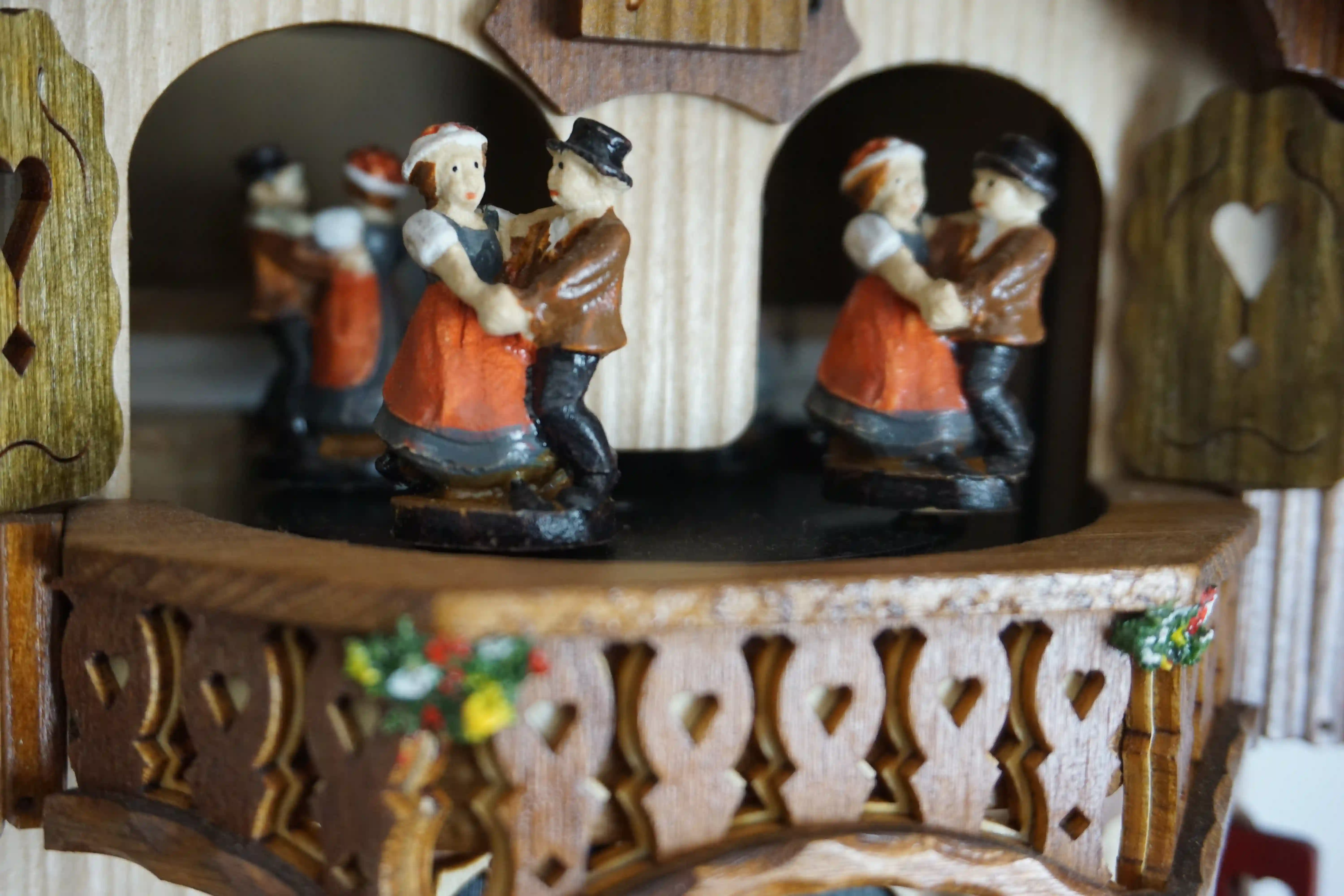Cuckoo Clock Wood Chopper 1 Day Movement with Music (5) chalet authentic black forest cuckoo clock with a red shingle roof and a wood chopper, as the music plays dancers dance, wood is being chopped and the water wheel turns, the clock is made by Hönes