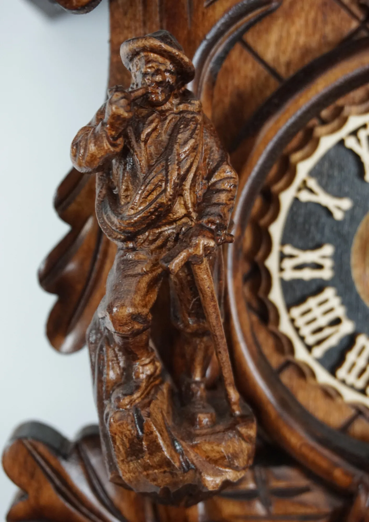 Cuckoo Clock Black Forest Wildlife 8 Day Movement (3) beautifully carved black forest brown mechanical cuckoo clock with an eagle on top of its crown, also decorated with a detailed figure of hunter and mountin goat. The dial is wraped with a hunting horn and beneath it hunting bag is hanging