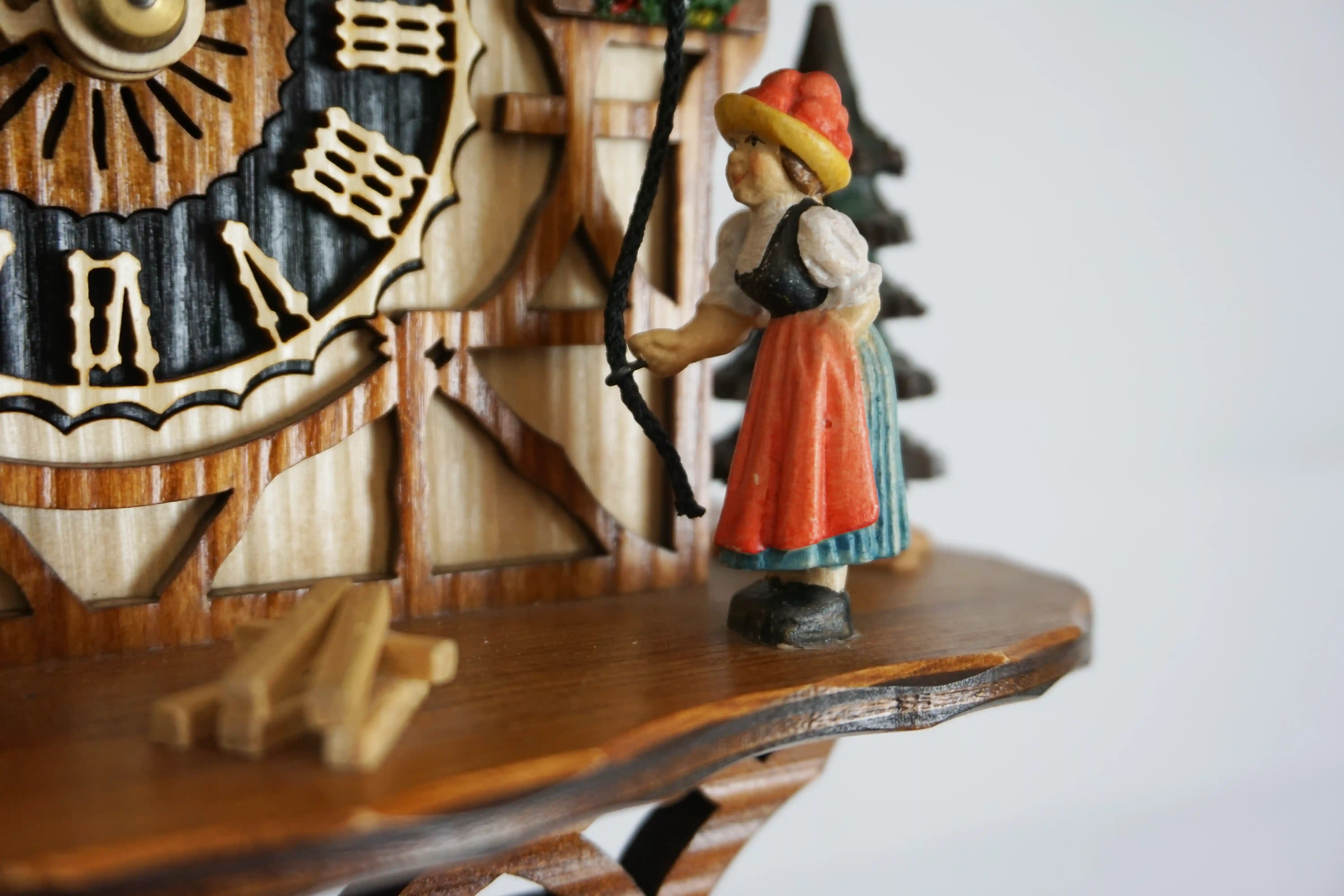 Cuckoo Clock Bell Ringer 1 Day Movement (5) Chalet colorful authentic black forest cuckoo clock with a nice shingle roof and a lady wearing traditional black forest clothing and rings the bell every hour made by Hönes