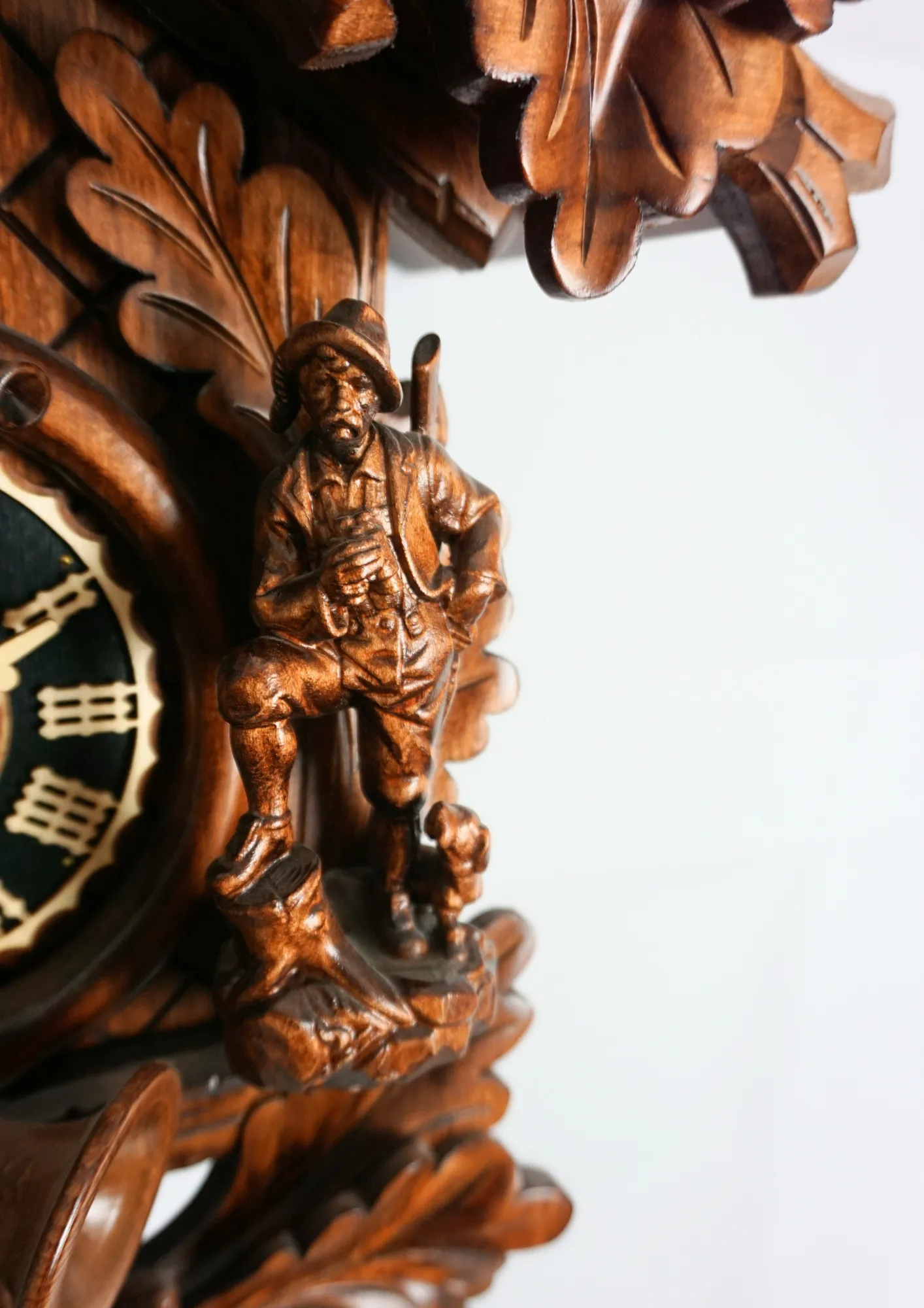 Cuckoo Clock Hunter Clock 8 Day Movement (4) Hand carved authentic mechanical brown black forest cuckoo clock in a hunter theme. Precisely carved deer head is decorating the top while there is a hunter and a falcon figure on the sides of the clock. The clocks dial is wraped with a hunting horn while