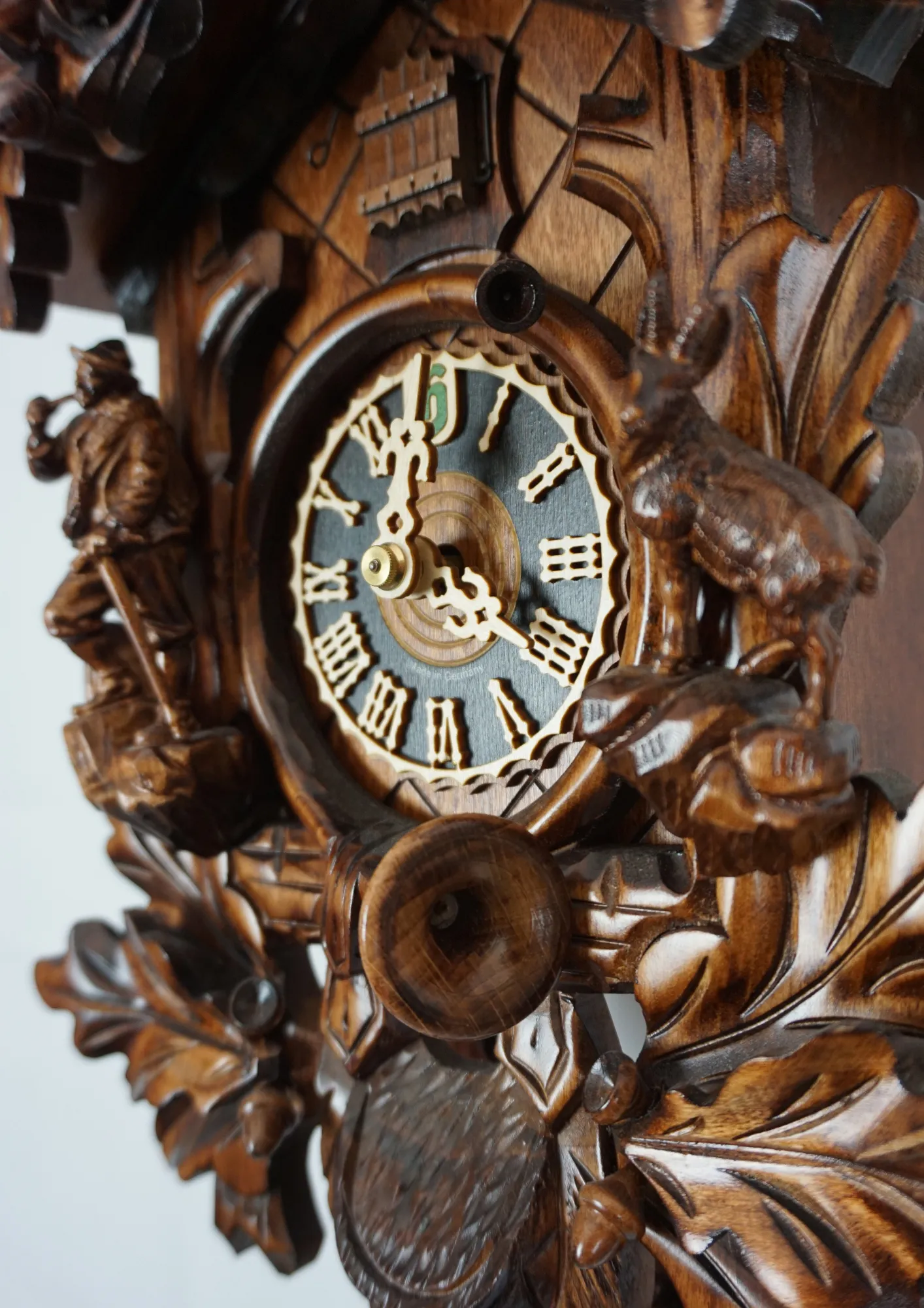 Cuckoo Clock Black Forest Wildlife 8 Day Movement (5) beautifully carved black forest brown mechanical cuckoo clock with an eagle on top of its crown, also decorated with a detailed figure of hunter and mountin goat. The dial is wraped with a hunting horn and beneath it hunting bag is hanging