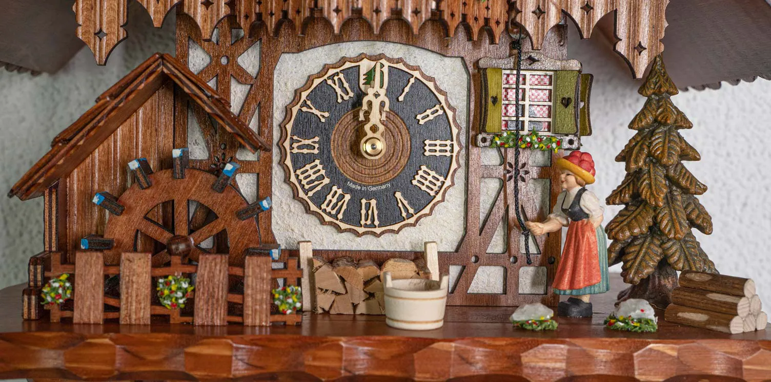 Cuckoo Clock Bell Ringer, Cottage House 1 Day Movement Music (5) Cottage brown-white mechanical black forest cuckoo clock with black forest lady in traditional dress with bollenhut ringing the house bell, while music is being played dancers dance and water wheel turn. made by Hönes