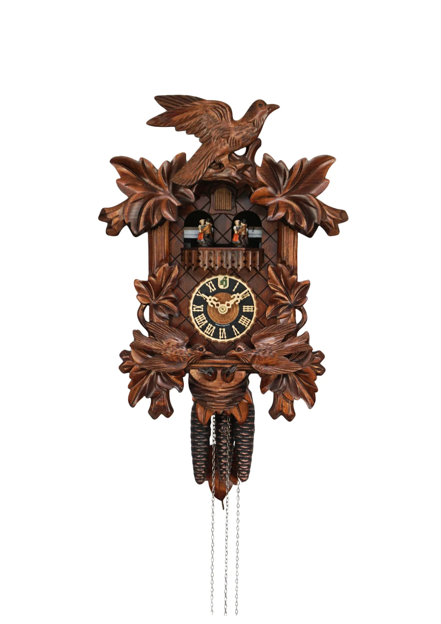 Traditional hand carved black forest mechanical cuckoo clock with music, decorated with two birds moving and feeding the offspring in the nest, dancers dance with music