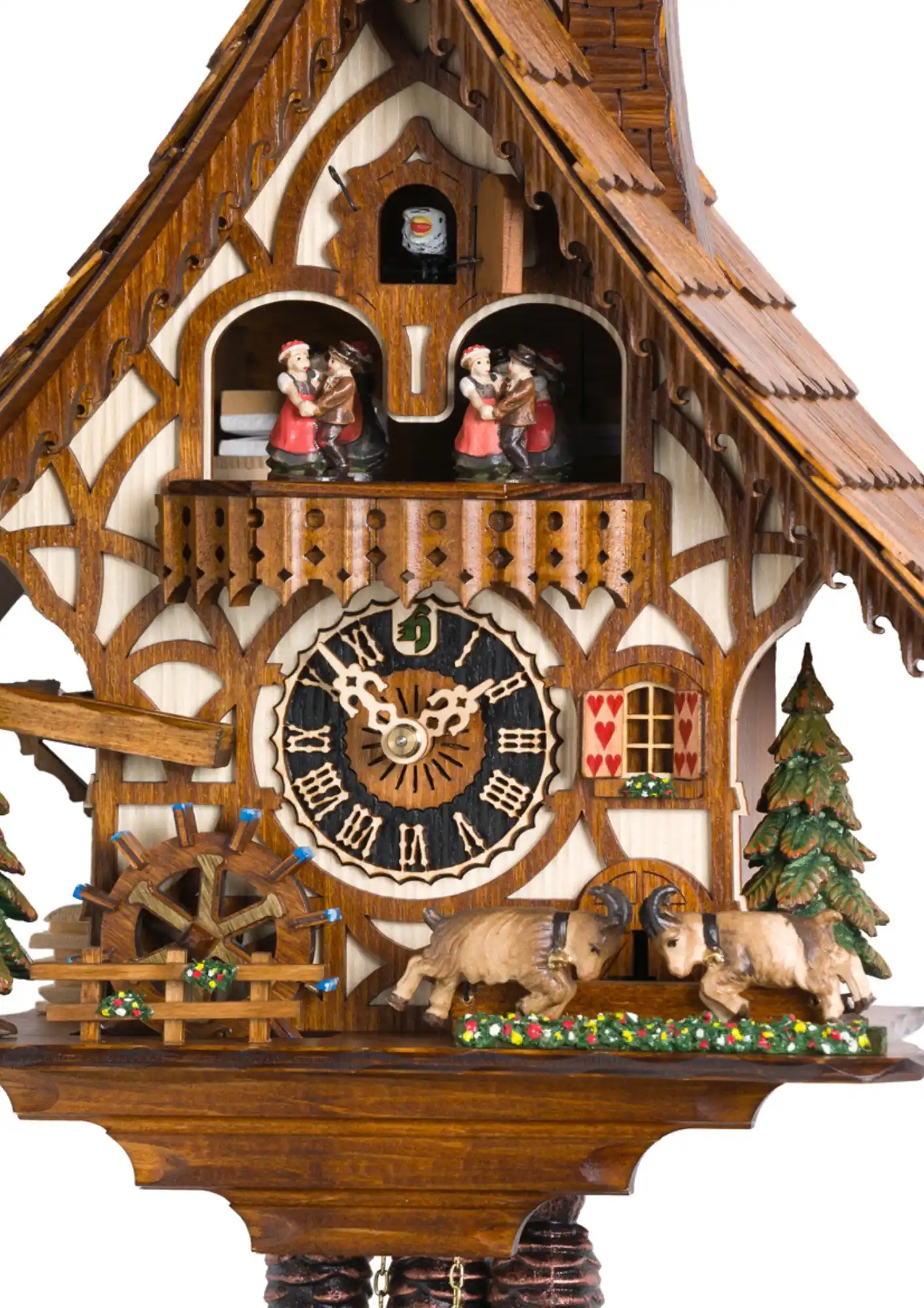 A chalet-style Black Forest cuckoo clock with fine details and two mountain goats sparring in the front. Dancers dance, water wheel turns and the goats are bumping their heads as the music plays. Made by Hönes