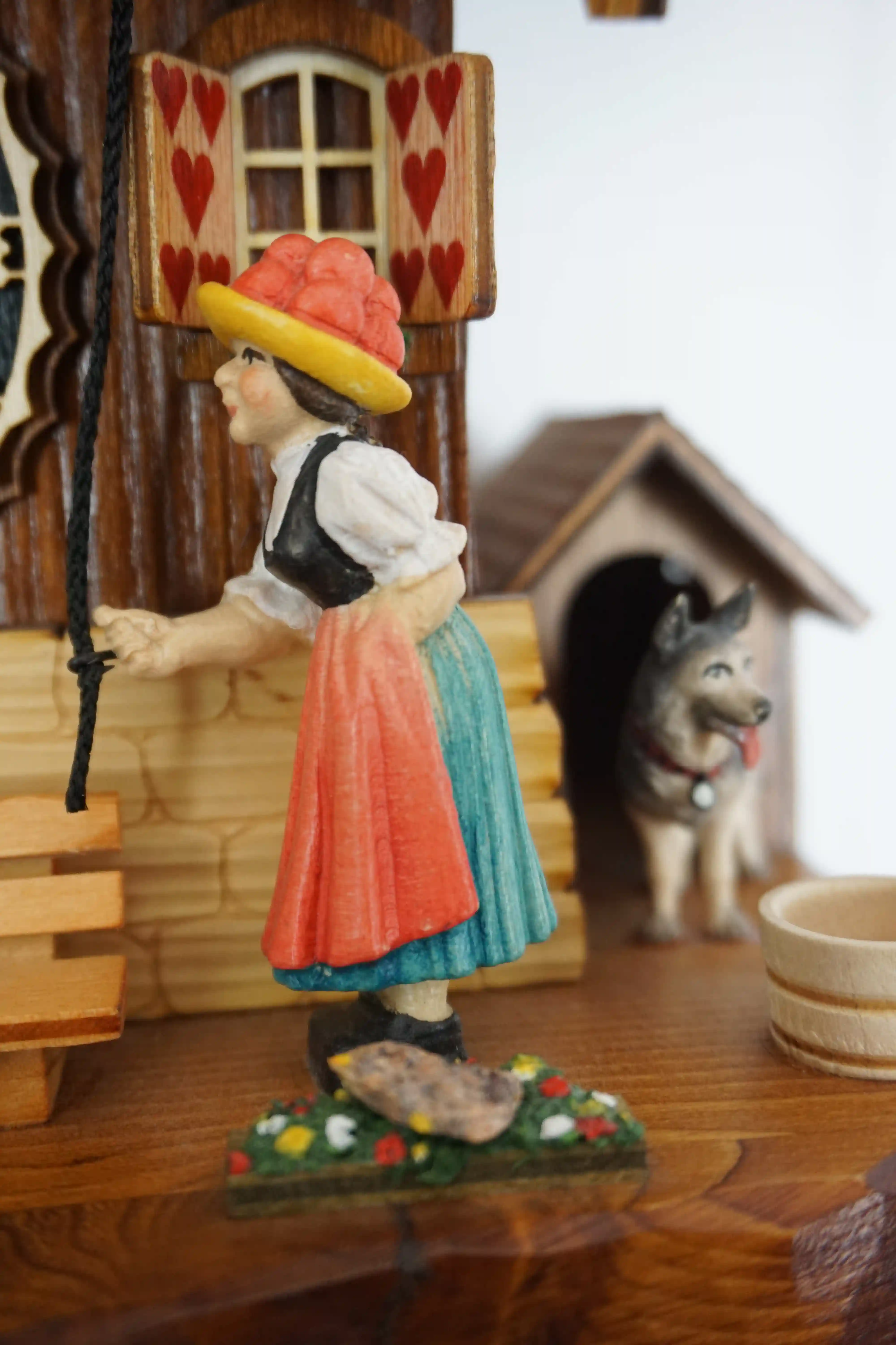 Cuckoo Clock Bell Ringer 1 Day Movement Music (4) Chalet style authentic mechanical black forest cuckoo clock with shingle roof, church tower bell and black forest lady wearing traditional clothing, the lady rings the bell together with the cuckoo sound, music plays dancers dance and water wheel turns