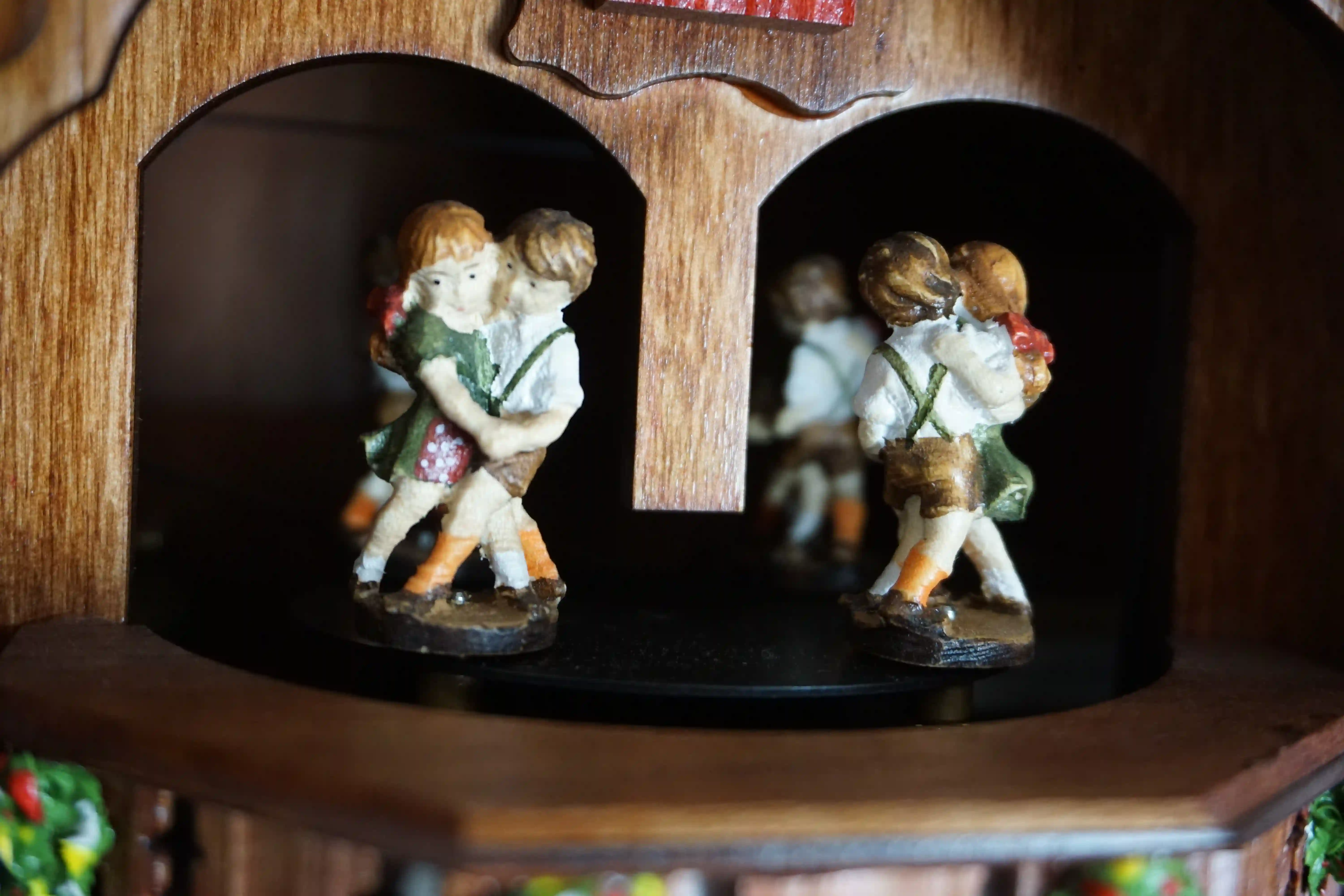 Chalet shingle roof mechanical black forest cuckoo clock with presice attention to detail. The kids are turning their heads and kissing, water wheel turns and the dancers are dancing as the music is playing