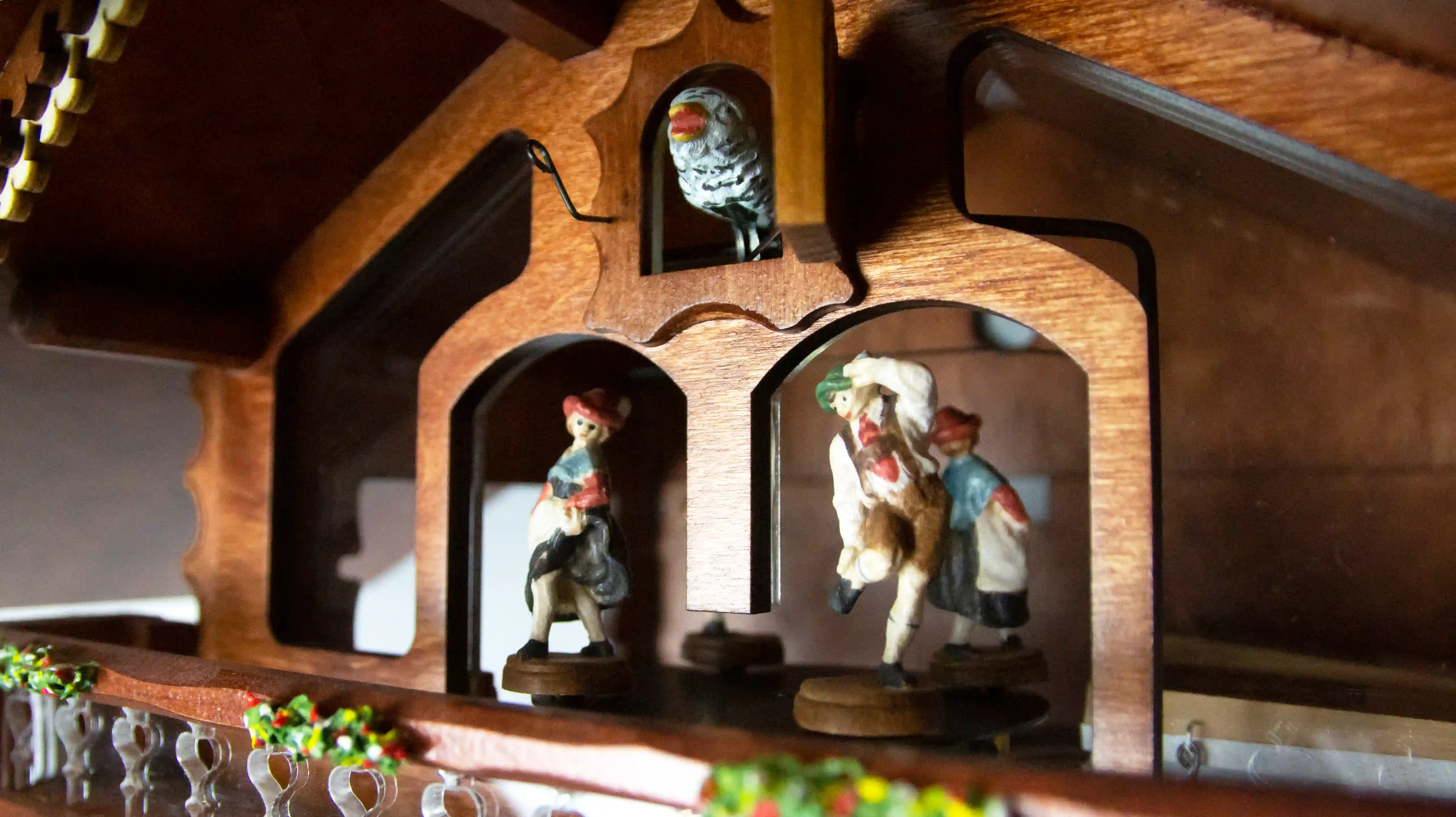 Authentic mechanical large coloful black forest cuckoo clock with transparent plexiglass and visible inside movement. It displays two beer drinkers in the beer garden and the lady with a rolling pin. As the music is playing dancers dance, water wheel turn
