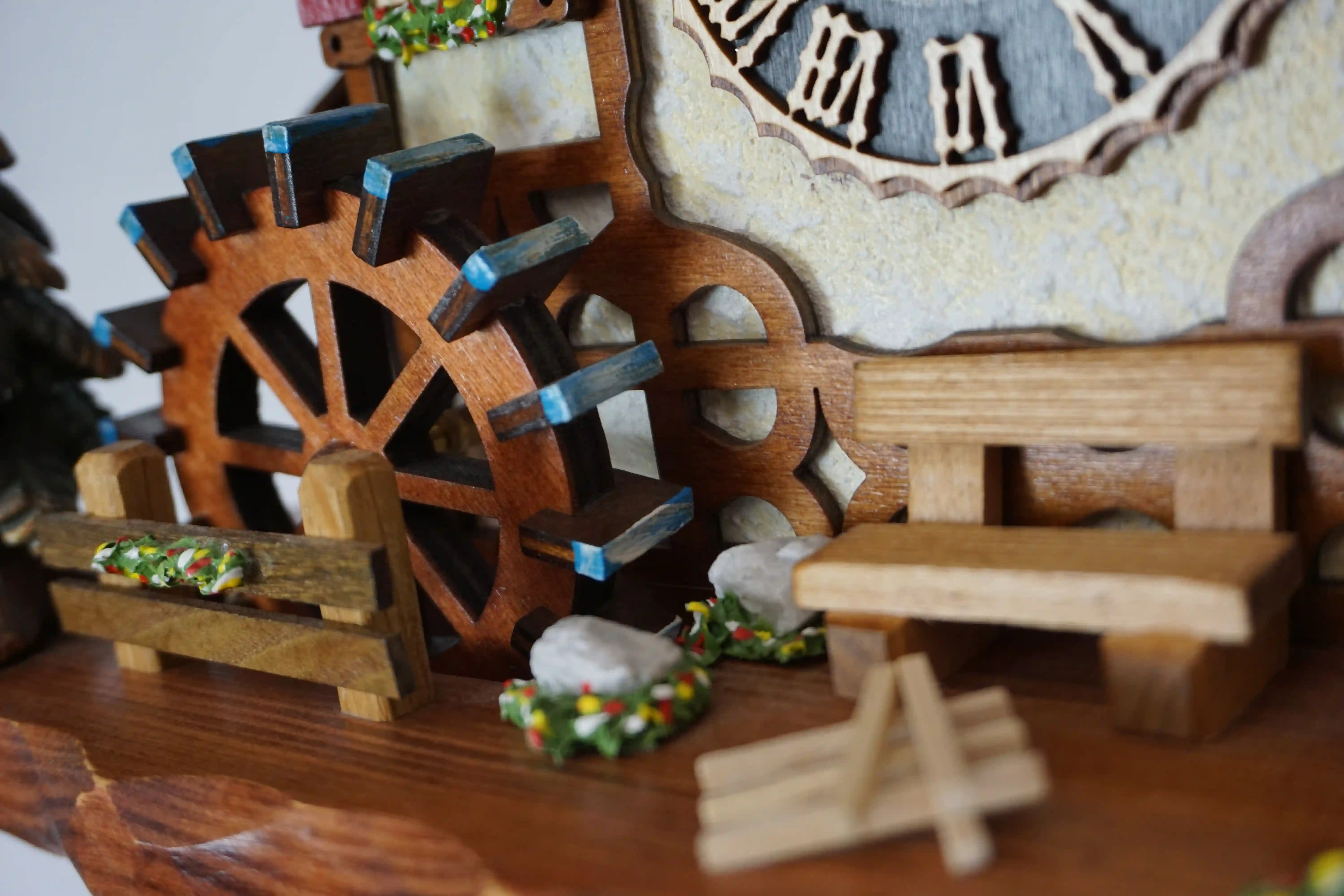 Chalet shingle roof mechanical black forest cuckoo clock with presice attention to detail. The kids are turning their heads and kissing, water wheel turns and the dancers are dancing as the music is playing
