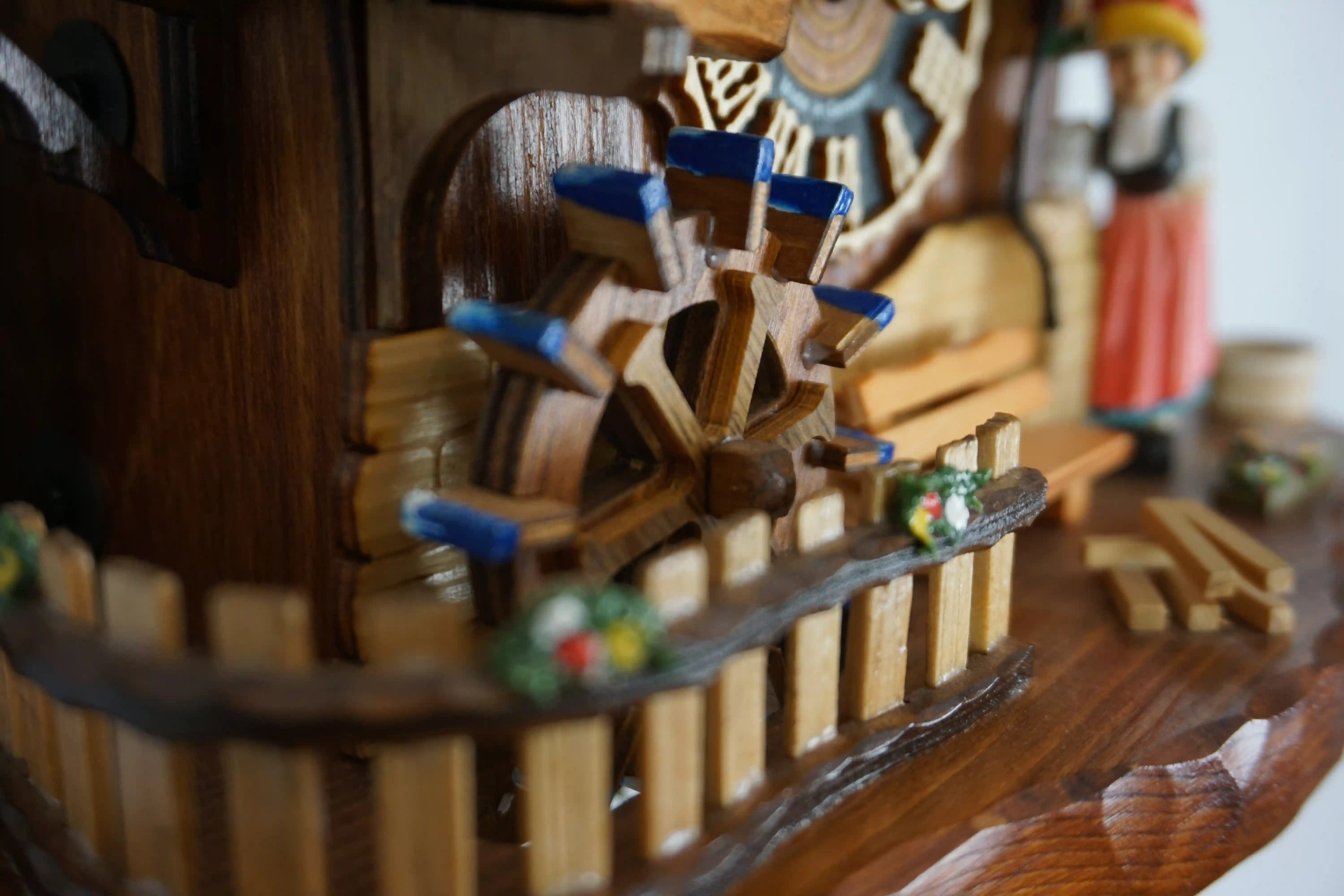 Cuckoo Clock Bell Ringer 1 Day Movement Music (5) Chalet style authentic mechanical black forest cuckoo clock with shingle roof, church tower bell and black forest lady wearing traditional clothing, the lady rings the bell together with the cuckoo sound, music plays dancers dance and water wheel turns